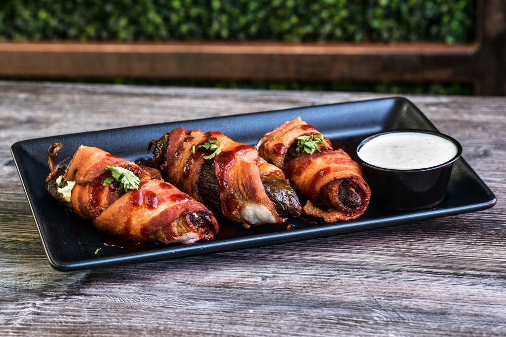 Bacon Wrapped Jalapenos · bacon wrapped jalapenos stuffed with
cream cheese • chipotle strawberry sauce  • served with ranch