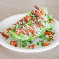 Wedge Salad · Iceberg wedge, bacon, tomatoes, blue cheese crumbles, and chives.