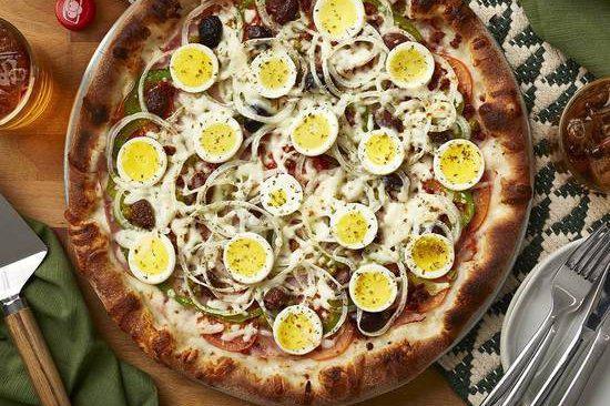 Portuguesa · Pizza sauce, mozzarella, ham, tomato, black olives, green peppers, bacon, onions, boiled eggs, peas and oregano.