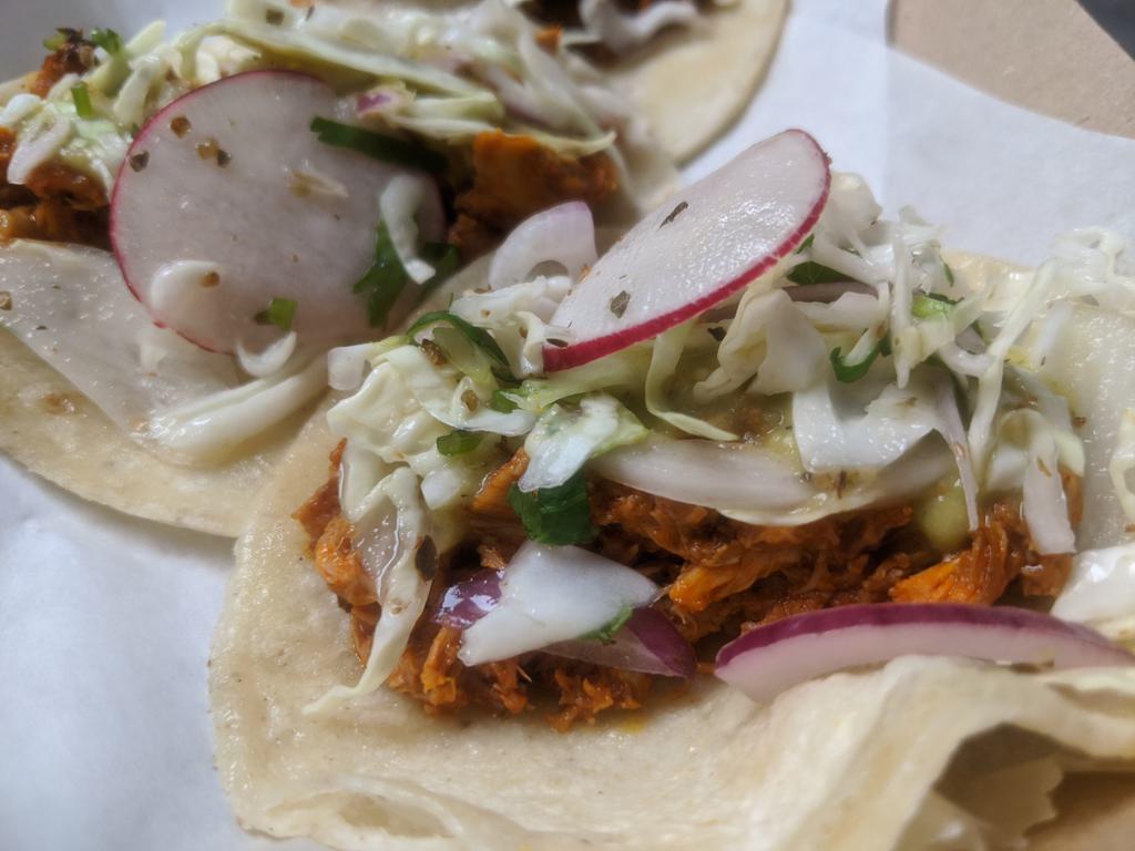 Chicken Tacos · Chicken thigh and legs slow and low for hours, tossed in chile guajillo and ancho sauce. Served on a warm tortilla, topped with a citrusy slaw and salsa verde. The dopest chicken taco in Chicago. Inspired by Deb Lefler.