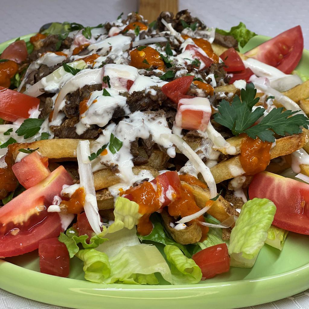 Shawarma Fries · Your choice of Shawarma Beef or Chicken added on top of French Fries, Tomato, Onion and Garnish of Garlic Sauce, Cucumber Sauce, Tahini Sauce, Shatta Sauce (Spicy) and Parsley with Sumac. *Fried in peanut oil.