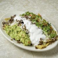 Nachos con Carne · Tortilla chips topped with guacamole, tomato, sour cream, cheese, beans and your choice of m...