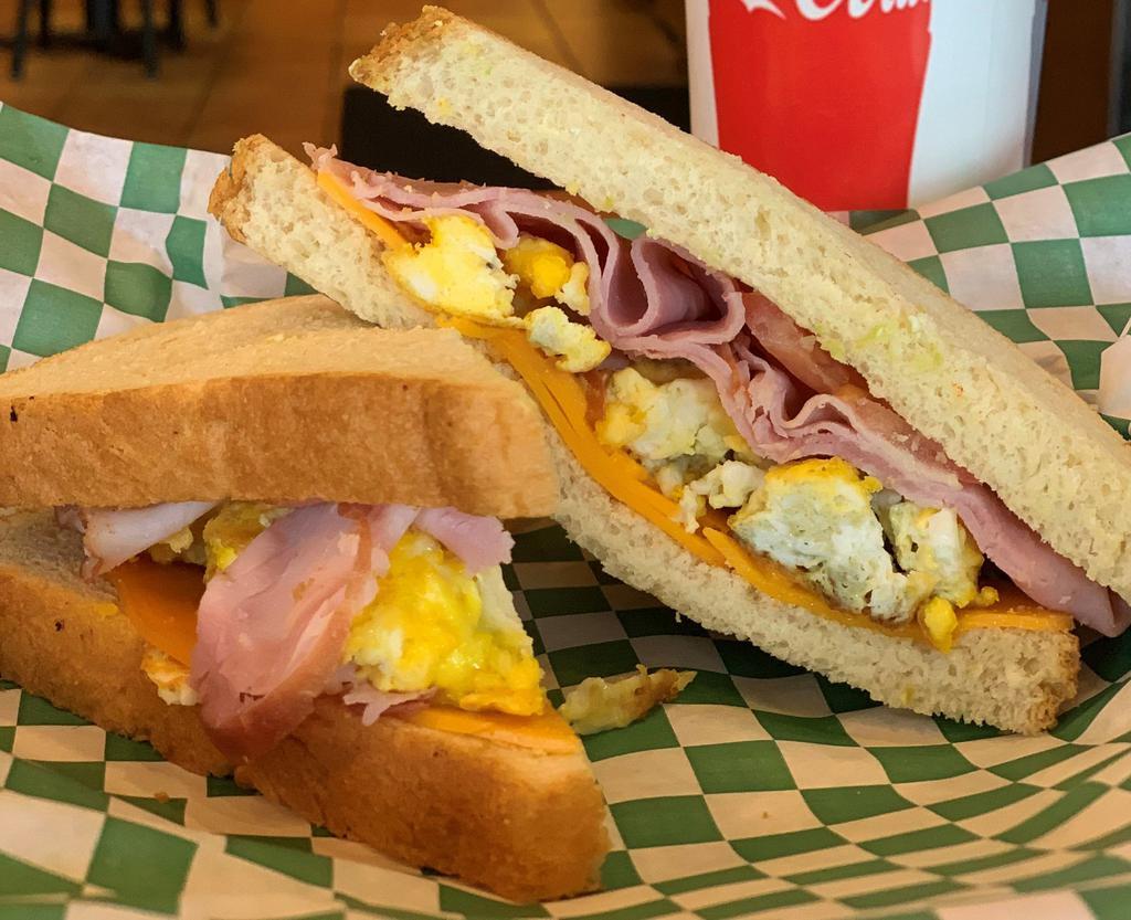 Breakfast Grilled Cheese · Fried or Scrambled Egg,  Black Forest Ham, Colby Cheddar & Tomatoes.  Grilled on Soft White Bread.
