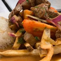 Lomo Saltado · Strips of tenderloin steak sauteed and flamed to perfection with onions, tomatoes, a bit of ...