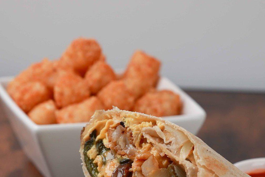 Veggie Trix · Eggs, tater tots, poblano peppers, onions, mushrooms and shredded cheddar jack cheese in a warm flour tortilla. Served with hot sauce.