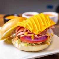 Happy Hammy Bagel · Ham, lettuce, tomato, red onion, cheddar cheese, mayo, and mustard on a toasted plain bagel.