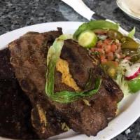 Costillas De Res  · two beef ribs seasoned and grilled to taste, served with rice, beans, salad and corn tortill...