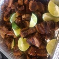 Chicharon · Crispy pork belly garnished with lime and red onion.