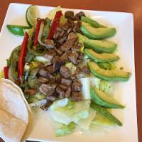 Steak Fajita Salad · Crisp romaine lettuce, grilled steak, fajita veggies (red and green bell peppers and onions)...