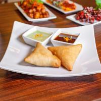 Samosa 2 PCs - Vegan · 2 pieces. Lightly fried pastry with a savory filling of spiced potatoes and peas. Served wit...
