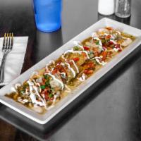 Tamale Bite · Homemade pork tamales bites, topped with green sauce, pico de Gallo, sour cream, and queso f...