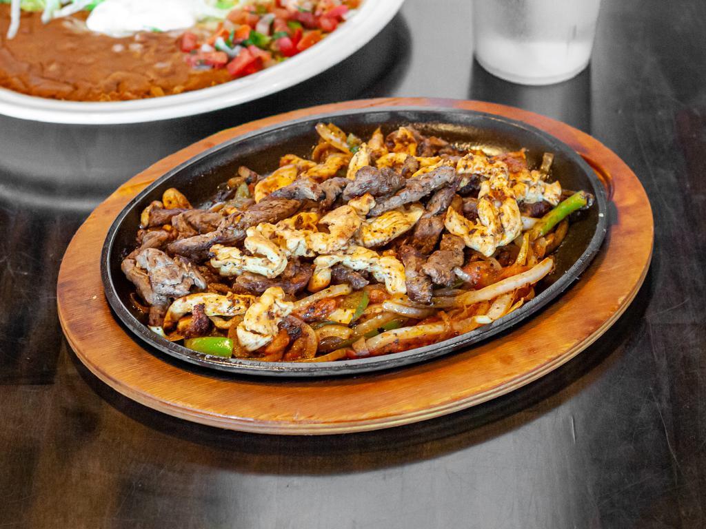 Fajitas · Choice of grilled chicken, steak, or mix. Onions, tomatoes, and bell pepper. Garnished with lettuce, sour cream, pico de Gallo, and guacamole. Beans, rice, and tortillas.