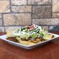 Classic Nachos · Our classic nachos feature a bed of fried tortilla chips, rice, beans and your choice of aut...