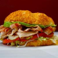 Avocado Club Sandwich · Turkey, bacon and avocado on a croissant with mayo, mustard, lettuce, tomato, onions and dil...