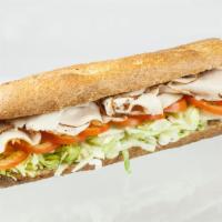 Turkey Feast Sandwich · Pile of freshly sliced turkey breast on a wheat baguette with lettuce, tomato and mayo. 