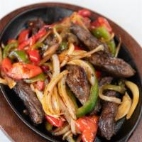Fajitas De Res · Mixed with bell peppers and onions. Side of cheese, lettuce, and tomato.
