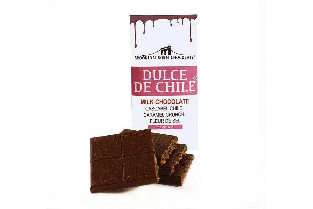 Dulce de Chile Milk Chocolate Bar · Ingredients: milk chocolate (pure cane sugar, milk, cacao butter, cacao beans, soy lecithin, vanilla bean), cascabel chile, sugar, toasted rice (rice, sugar, glucose, malt flavor, salt), butter, fleur de sel - Creamy Caramelized Kicks Our Dulce de Chilé bar expands on the familiar taste of creamy 42% milk chocolate and toasted rice crispy with spicy notes of cascabel pepper and a dash of sea salt. That first bite is so familiar—sweet creamy milk chocolate melting between clusters of crunchy toasted rice. But then, something else challenges the taste buds. Faint notes of caramel merge with the subdued yet spicy heat of cascabel pepper while a dash of sea salt solidifies the union. Just like that, the familiar has become the unique. From the Chef: “One day I tried the cascabel pepper and thought it was fantastic with caramel.” The name is a twist on the Dulce de Leche because it’s a milk chocolate bar, it has caramel and there’s the chile.