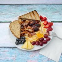 2. More Protein Please · Eggs, sausage, and bacon with a side of fruits.