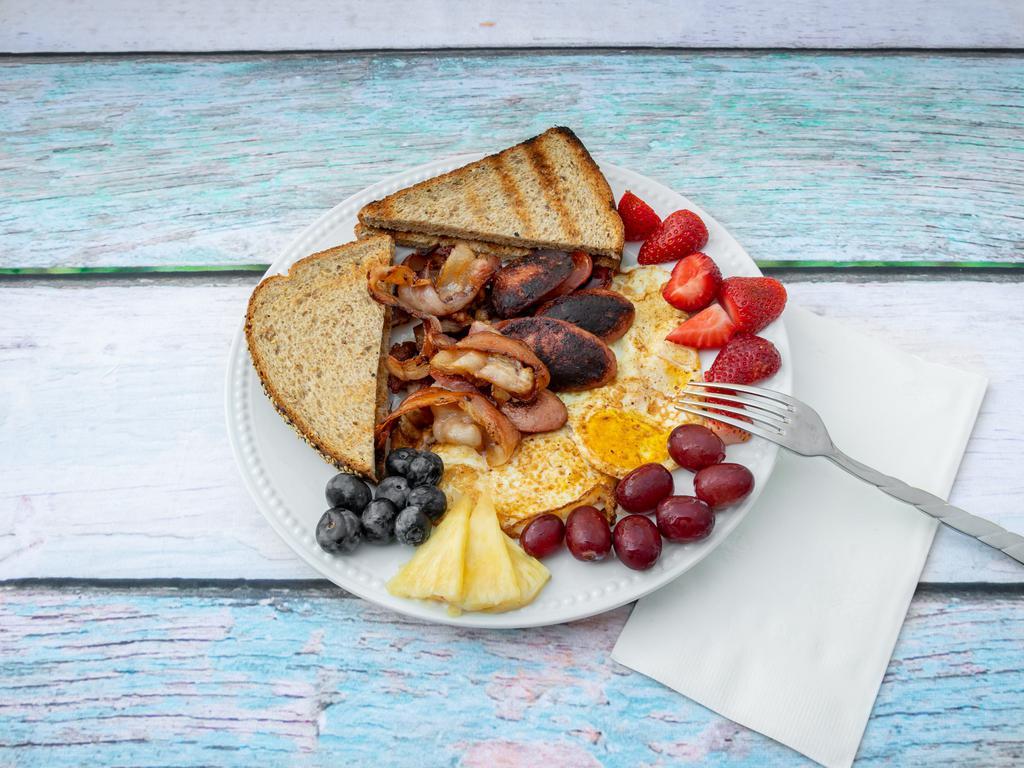 2. More Protein Please · Eggs, sausage, and bacon with a side of fruits.