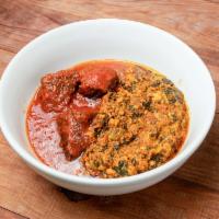 Egusi · Savory spinach stew with ground melon seeds served with a side of stew and an assortment of ...