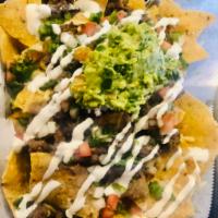 Nachos · Crispy corn tortilla chips served with our homemade cheese sauce, refried beans, avocado, so...