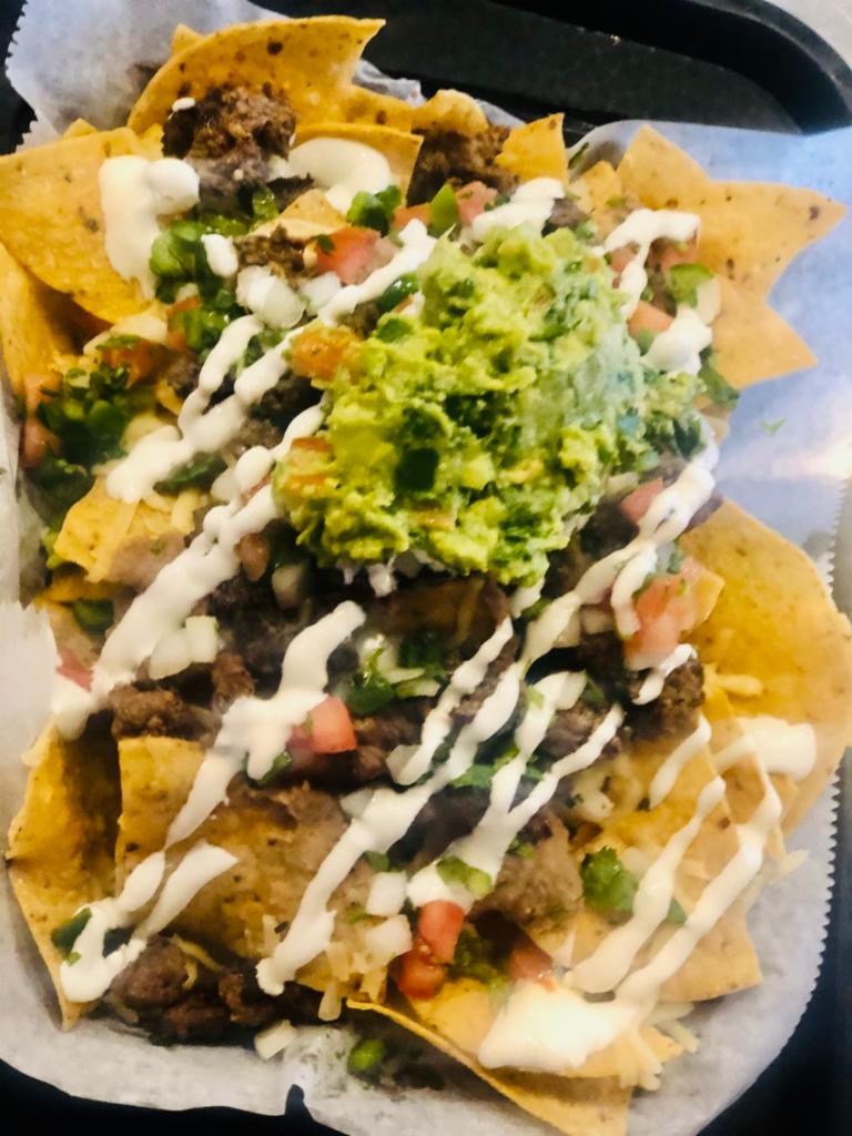 Nachos · Crispy corn tortilla chips served with our homemade cheese sauce, refried beans, avocado, sour cream, guacamole, and fresh pico de gallo. Add proteins for an additional charge.