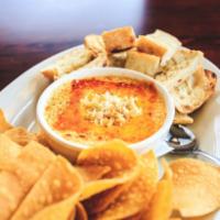 Three Cheese Crab Dip · Fresh crabmeat blended with roasted garlic, mascarpone, cheddar and cream cheese served hot ...