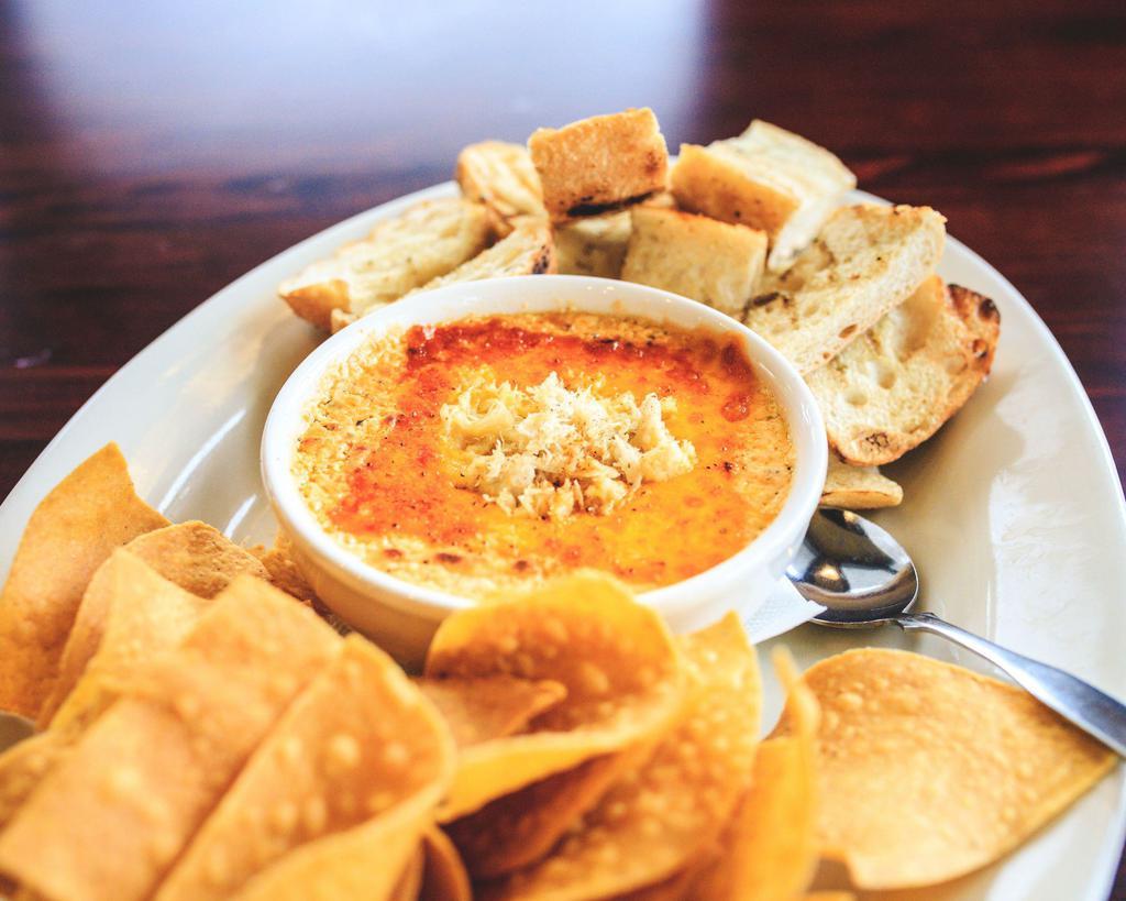 Three Cheese Crab Dip · Fresh crabmeat blended with roasted garlic, mascarpone, cheddar and cream cheese served hot with wood-grilled ciabatta bread and tortilla chips.