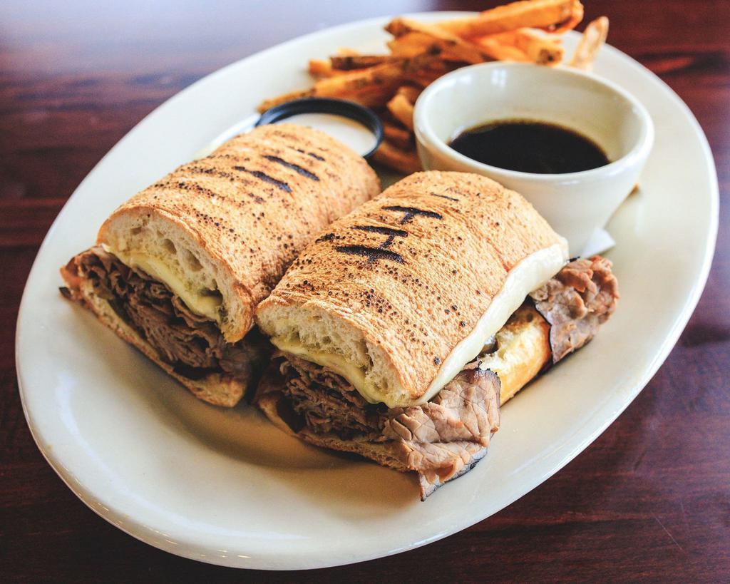 Roast Beef Sandwich · Sliced roast beef simmered in au jus served on grilled ciabatta bread with caramelized onions, provolone and a dipping cup of au jus with a side of horseradish mayo.  Served with a side of French fries.