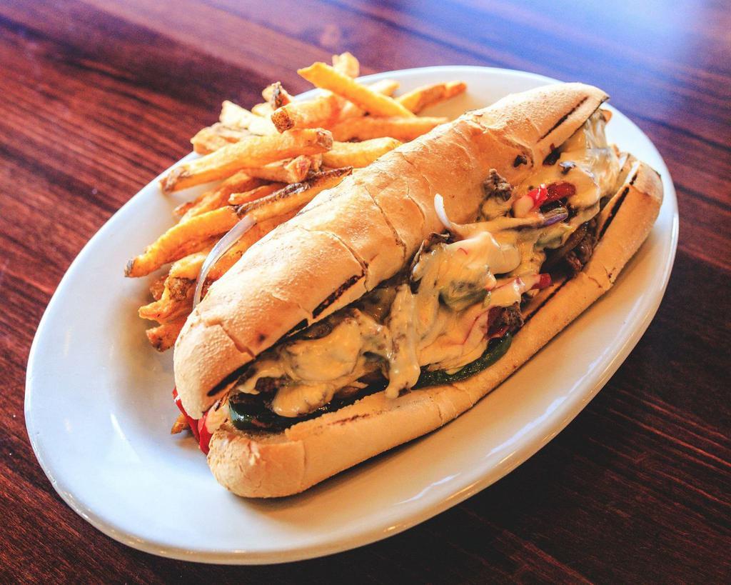 Oscar's Cheese Steak Sandwich · Sliced steak cooked with red and green peppers, onions, mushrooms and topped with queso cheese sauce served on a sub roll with a side of French fries.