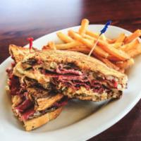 Oscar's Reuben · Corned beef served with sauerkraut, Swiss cheese and Thousand Island dressing on marble rye ...