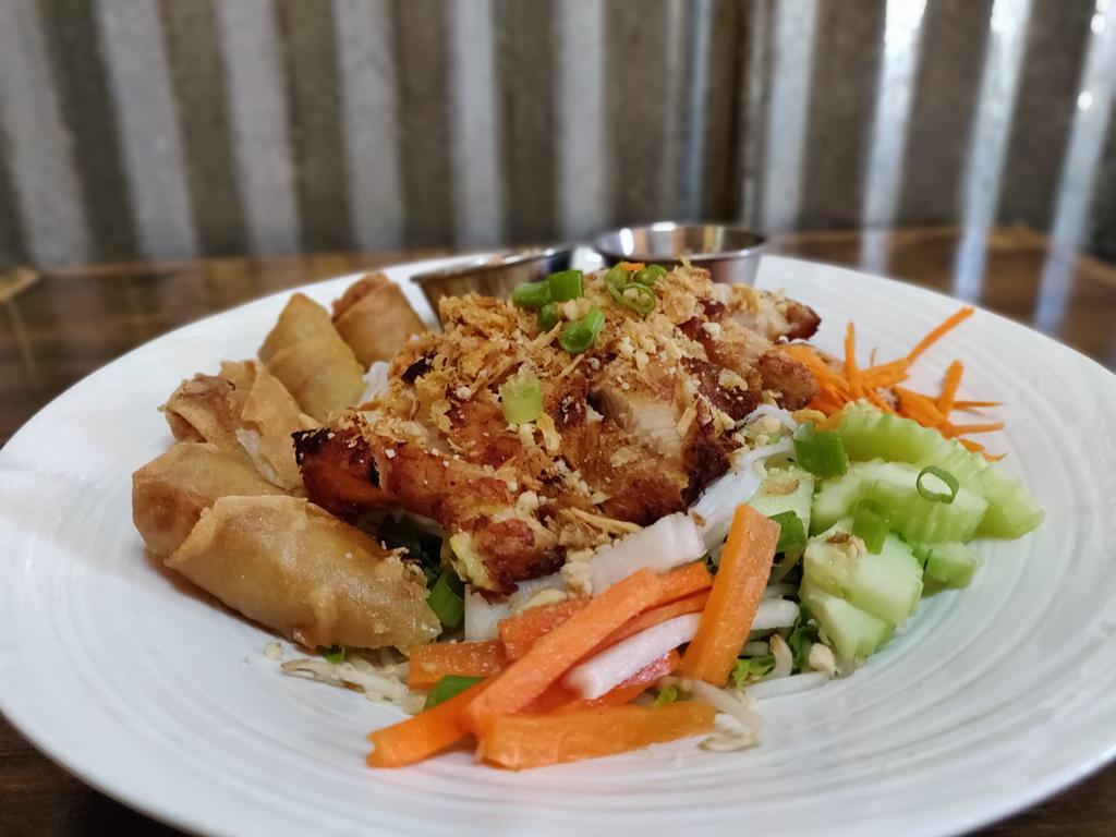 Rice noodles salad pork · Grilled pork with cold rice noodles,mixed salad,cucumber,bean sprouts,carrots,cilantro,green onion,basil,mint, deep fried vegetables rolls pieces and topped with ground peanuts. Served with a homemade sauce.