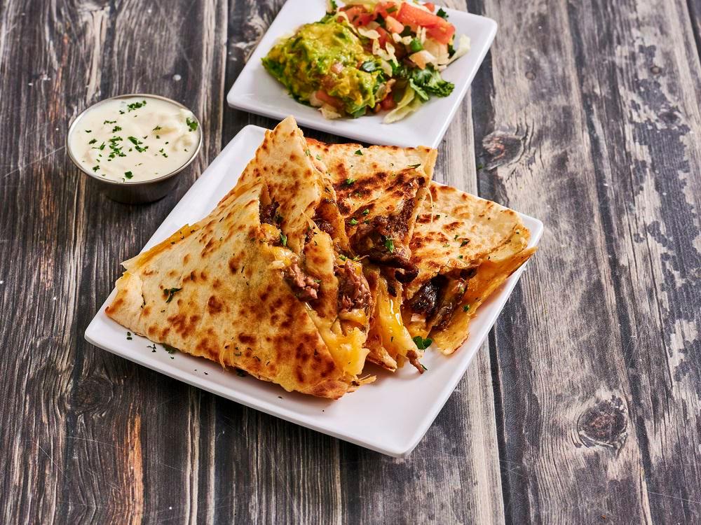 Steak Quesadilla · A large flour tortilla grilled with melted cheese served with lettuce, tomatoes, sour cream and guacamole.