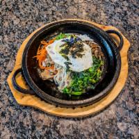 54. Dol-pan Bibim-Bap · Hot stone pan with rice, vegetables, fried egg, and your choice of bulgogi, tofu, dwaeji bul...