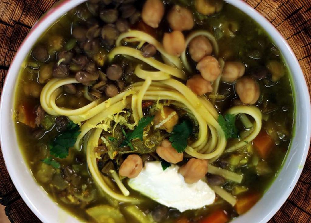 V-Noodles Soup آش رشته  · Traditional Persian soup with herbs, spinach, cilantro, turnips, oats lentils, noodles, beans, and chick peas slowly simmered served with aged dried yogurt and caramelized onions.