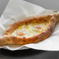 Adjarian Khachapuri · A boat-shaped bread with cheese, butter, and runny eggs.