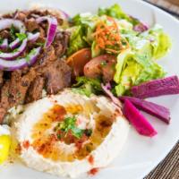 Beef Shawarma · Marinated layers of tender beef, cooked on a broiler, served with onions, and tahini.