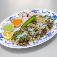 Taco · Traditional street style taco served on corn tortilla, topped with cilantro and onions.