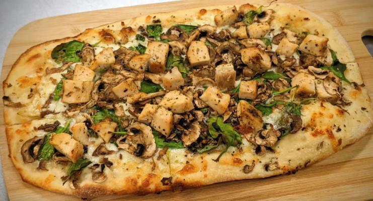 Roasted Garlic Chicken Flatbread · Thin crust topped with white creamy garlic sauce, mushrooms, mozzarella and Monterey Jack cheese blend, roasted garlic, fresh spinach, and roasted chicken breast.