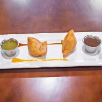 Samosa · Hand made pastry stuffed with potatoes, green peas and spices, deep fried and served with ta...