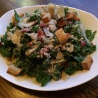 Kale Caesar Salad · Shaved Parmesan, croutons, bacon bits and home-made dressing.
