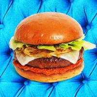 The New Classic Burger · Beef patty with lettuce, ketchup, caramelized onions, mayo, and melted swiss cheese on a flu...