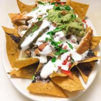 Chicken Nachos · Tortilla chips topped with Chicken, beans, cheese, guacamole, onions, cilantro, tomato, jala...