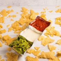 Queso and Chips · Seen in the middle of this Dip Trio... is that white liquid gold! 