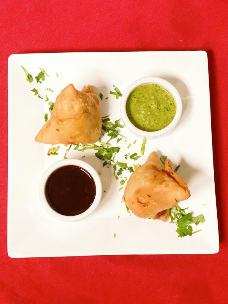 Vegetable Samosa · 2 triangular cnspy shell slutted with spiced potatoes, peas, carianda and served with chutney.
