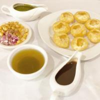 Pani Puri · Crispy puffed waffwes served with spicy mint wather chutney, potatoes and chick peas.