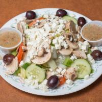Famous Greek Salad · Lettuce, tomatoes, mushrooms, onions, green peppers, feta cheese, Greek olives and bread wit...