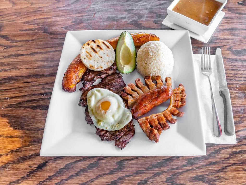 Bandeja Paisa · Grilled meat, Colombian sausage, pork rinds, fried egg, rice, corn cake, fried plantains, and red beans.