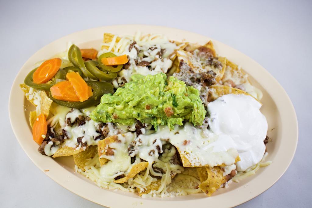 Super Nachos · Choice of meat with beans, cheese, sour cream, guacamole y jalapeno.