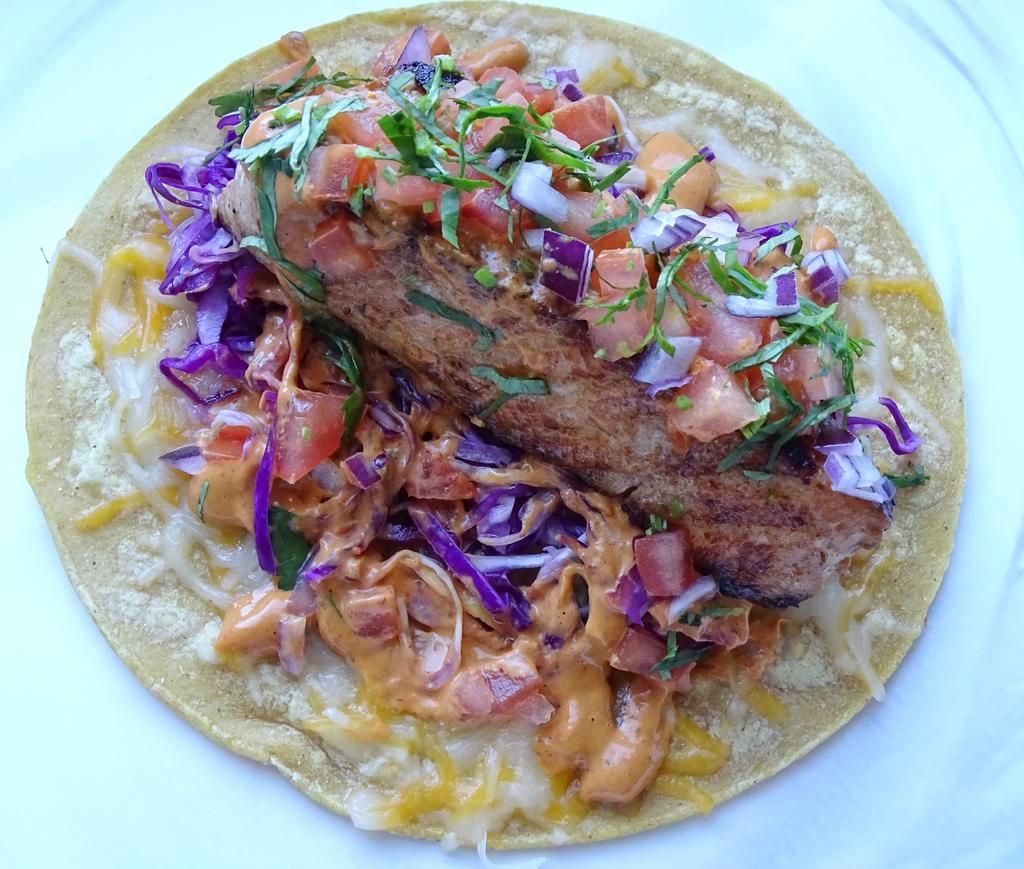 Fish Taco · Yellow corn tortilla, grilled salmon, cheese, green and red cabbage, tomatoes, red onion, cilantro, and special chipotle sauce.